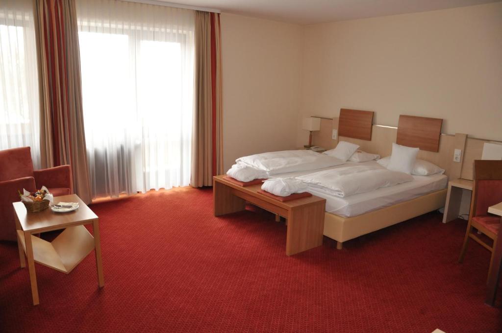 Postel nebo postele na pokoji v ubytování Hotel am Kurpark