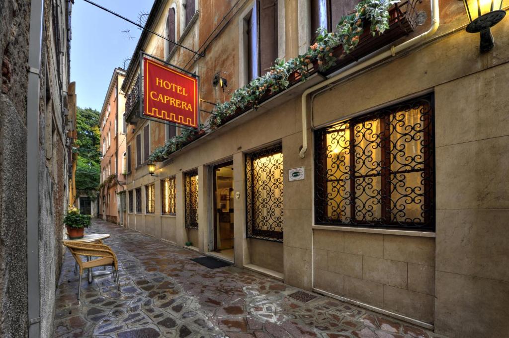 une rue vide avec une chaise devant un bâtiment dans l'établissement Hotel Caprera, à Venise