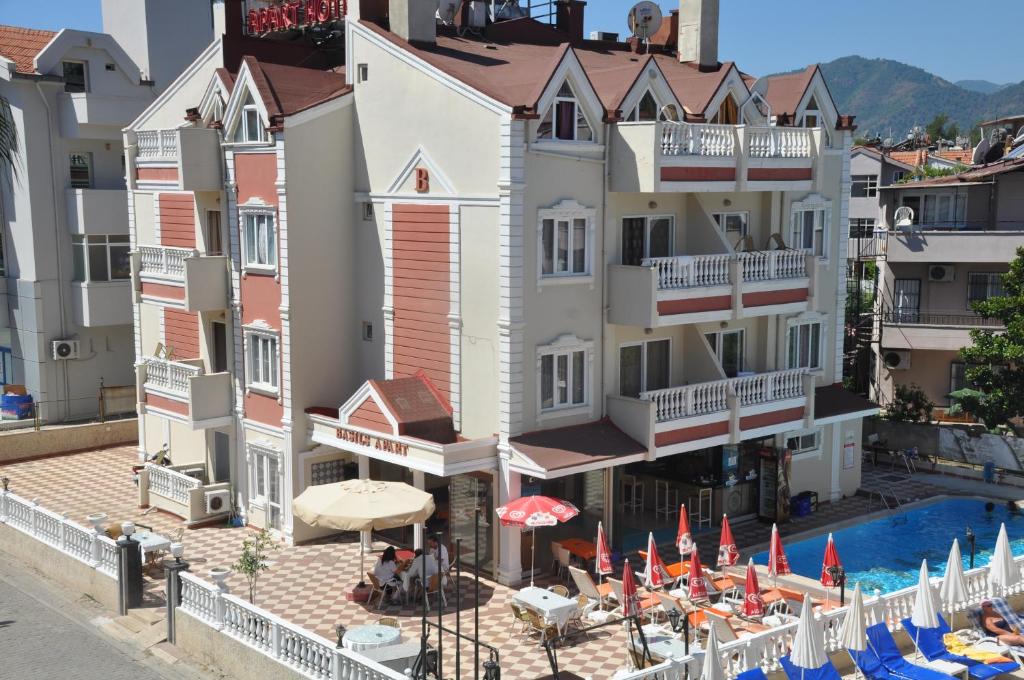 Blick auf ein Hotel mit Pool und Sonnenschirmen in der Unterkunft BASILS APART HOTEL in Marmaris