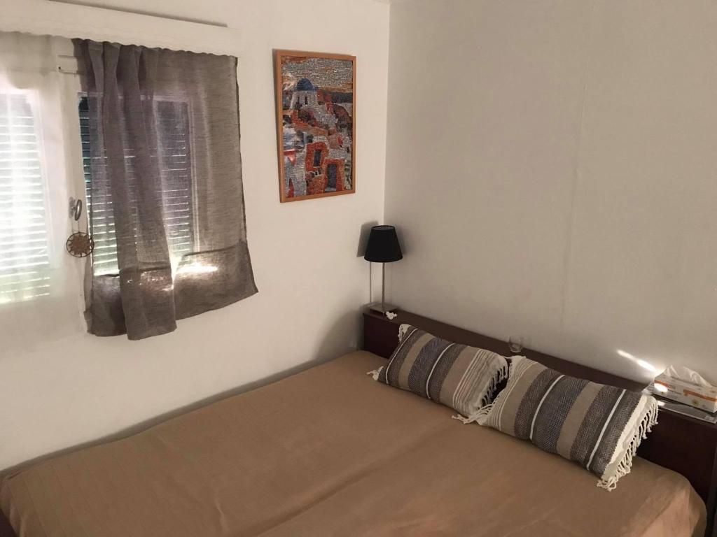 Bett in einem Zimmer mit Fenster in der Unterkunft Kokos Traditional Family House in Kap Sounion