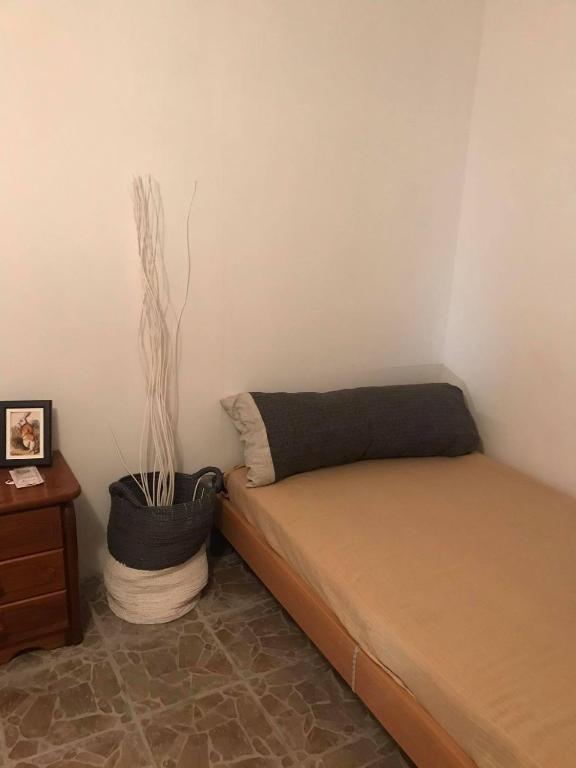 ein Schlafzimmer mit einem Bett und einer Topfpflanze in der Unterkunft Kokos Traditional Family House in Kap Sounion