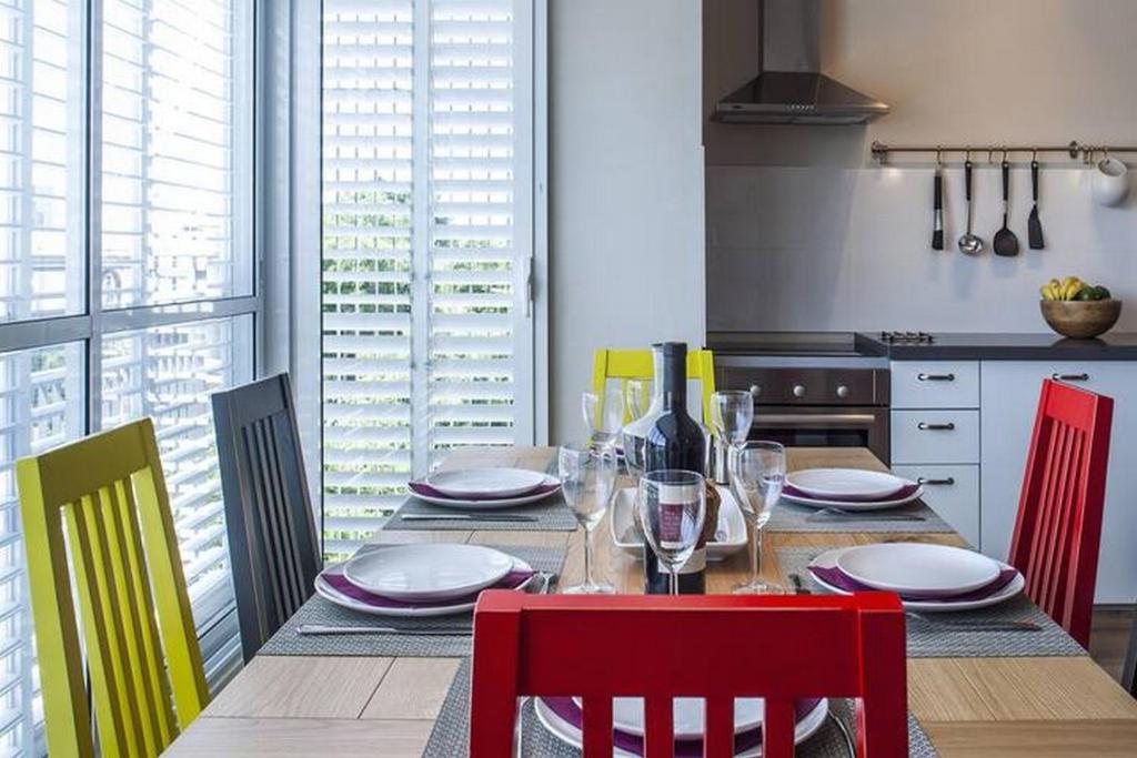 a kitchen with a table with chairs and wine bottles at Simple 2BR in Sderot Chen 1 by HolyGuest in Tel Aviv
