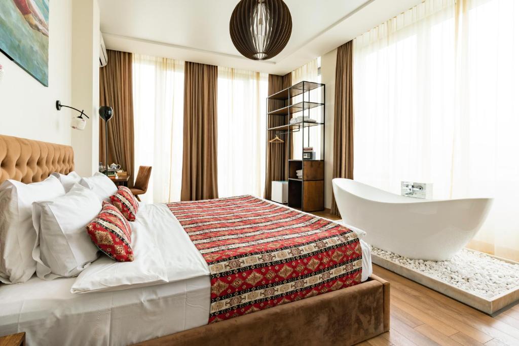 a bedroom with a large bed and a bath tub at Hotel Flower in Tbilisi City