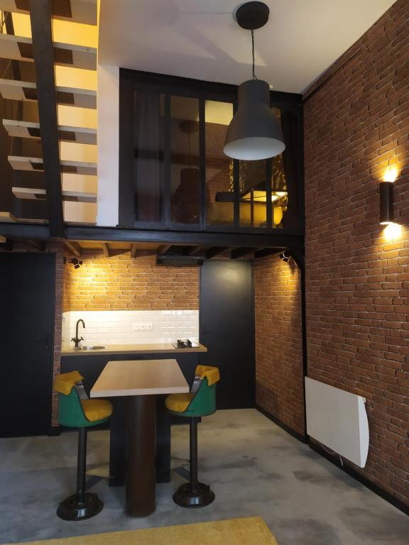 a kitchen with a table and chairs and a brick wall at Spa Mensignac in Mensignac