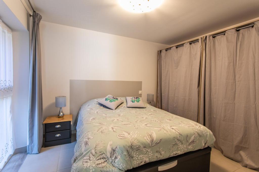 ein Schlafzimmer mit einem Bett mit zwei Kissen darauf in der Unterkunft L&#39;écureuil dans La vieille maison centre ville d&#39;Embrun in Embrun