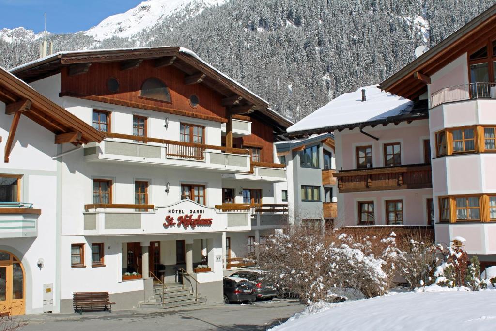 a hotel with a snow covered mountain in the background at Hotel St. Nikolaus in Ischgl