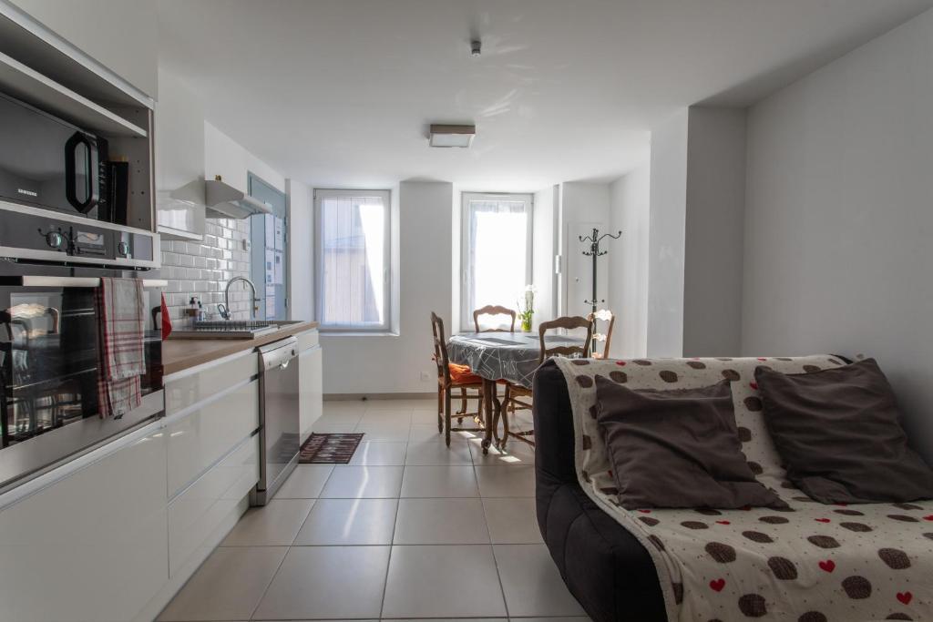 eine Küche und ein Wohnzimmer mit einem Sofa und einem Tisch in der Unterkunft L&#39;écureuil dans La vieille maison centre ville d&#39;Embrun in Embrun