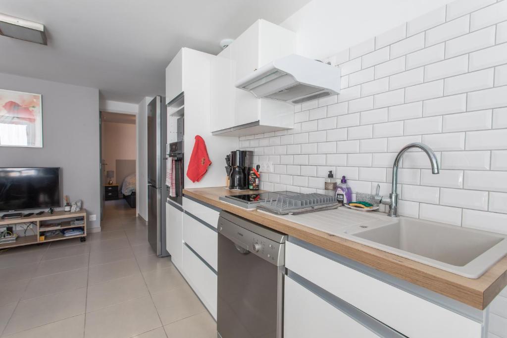 eine Küche mit einer Spüle und einer Arbeitsplatte in der Unterkunft L&#39;écureuil dans La vieille maison centre ville d&#39;Embrun in Embrun