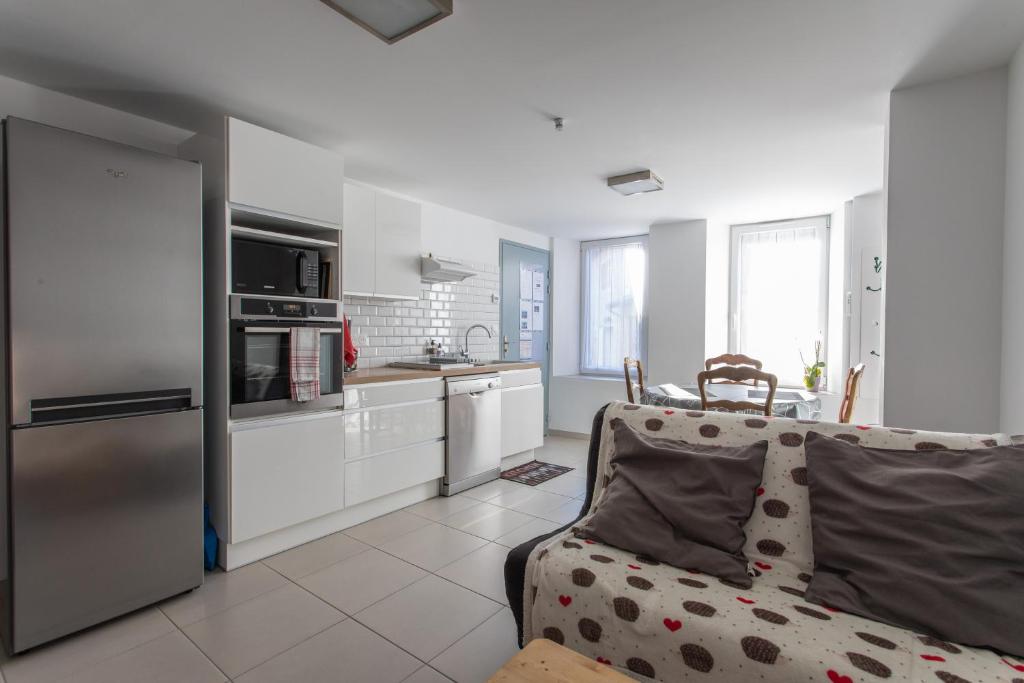 ein Wohnzimmer mit einem Sofa und einer Küche in der Unterkunft L&#39;écureuil dans La vieille maison centre ville d&#39;Embrun in Embrun
