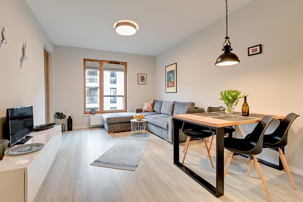 a living room with a table and a couch at 4 Seasons Jelitkowo + Beach in Gdańsk