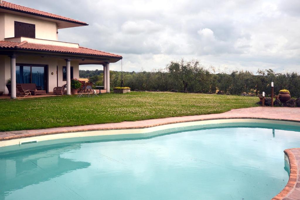 a swimming pool in front of a house at Country House Arborea in Bagnoregio