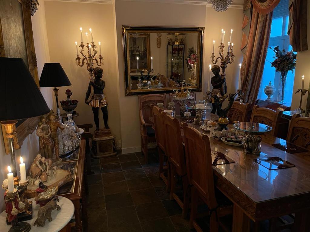 a dining room with a table and chairs with candles at Olivia House in Porthcawl