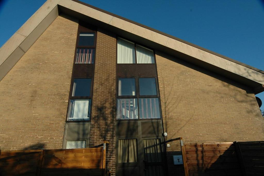 ein Backsteingebäude mit seitlichen Fenstern in der Unterkunft Wijk de Brabander 8 in Cadzand