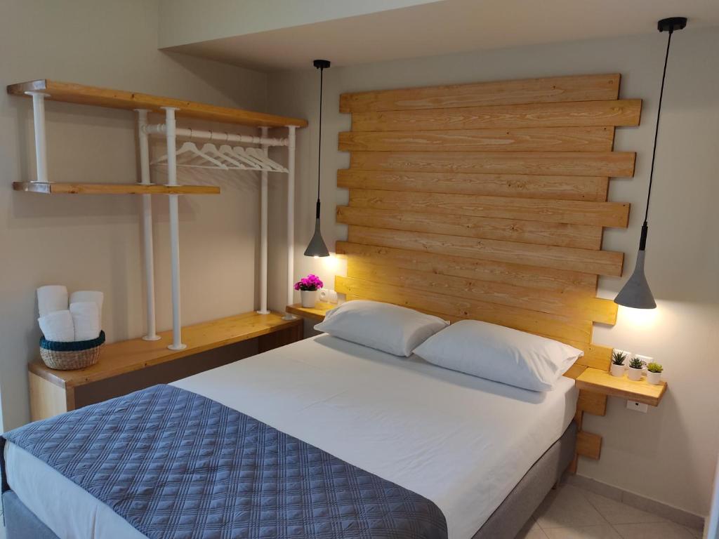 a bedroom with a large bed and a wooden wall at Vasilis Studios in Kiveri