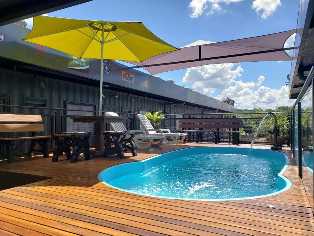 ein Pool auf einer Terrasse mit einem Sonnenschirm in der Unterkunft Hotel Bonito Motobox - HOTEL CONTAINER in Bonito