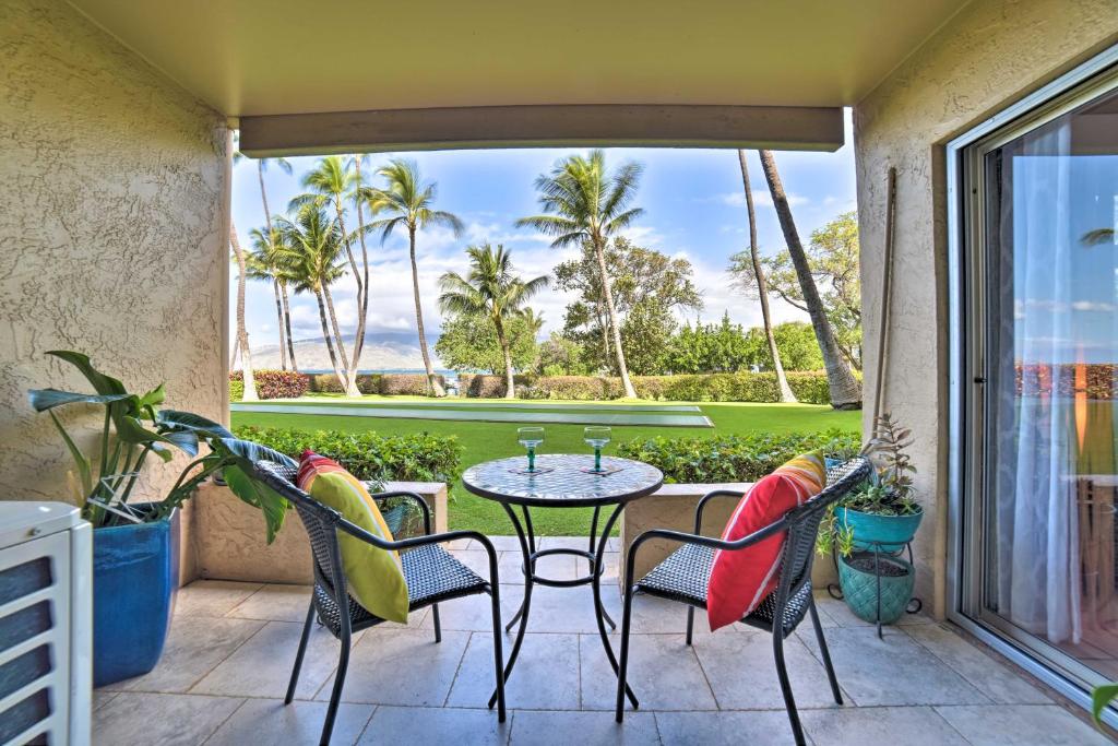 a patio with a table and chairs on a balcony at Ocean-View Kihei Condo with Lanai Steps to Beach! in Kihei