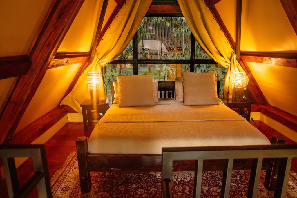 a bed in a room with a large window at Shamba lodge arusha in Olmotoni