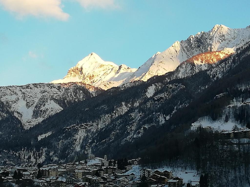 una montagna innevata con una città di fronte di Villa Irma a Chiesa in Valmalenco