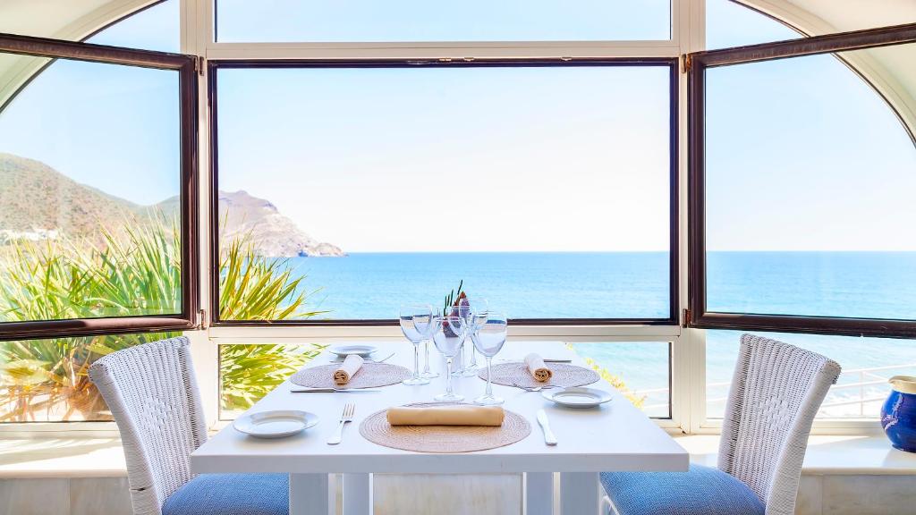 una mesa blanca con sillas y vistas al océano en Doña Pakyta, en San José