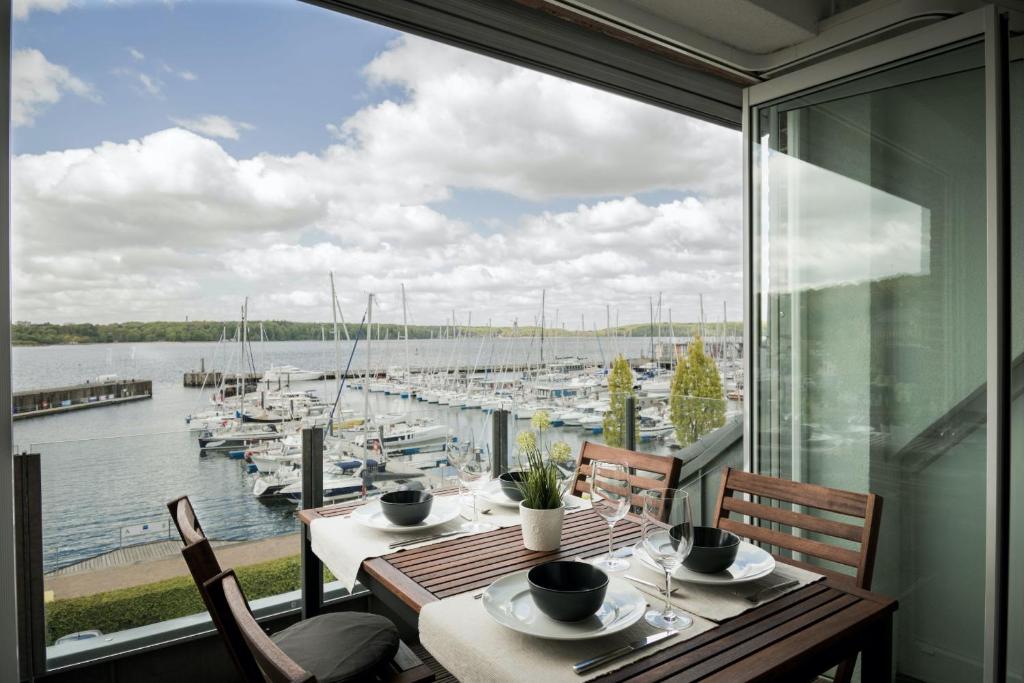 een eetkamer met uitzicht op een jachthaven bij fewo1846 - Baltic Lodge - komfortable Maisonettewohnung mit 3 Schlafzimmern, Balkon und Blick auf die Marina Sonwik in Flensburg