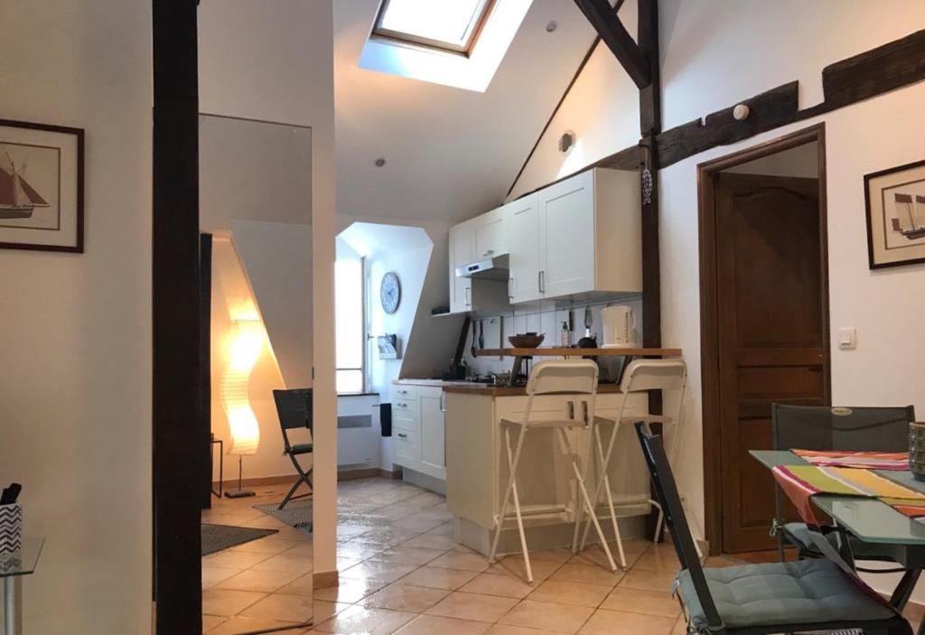 a kitchen with white cabinets and a table in a room at Appartement de charme rue du Château in Auray