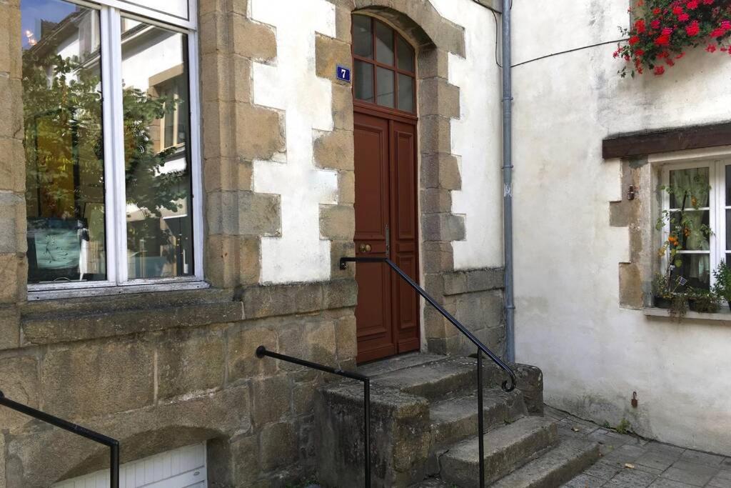 a building with a brown door and stairs in front at Appartement de charme rue du Château in Auray