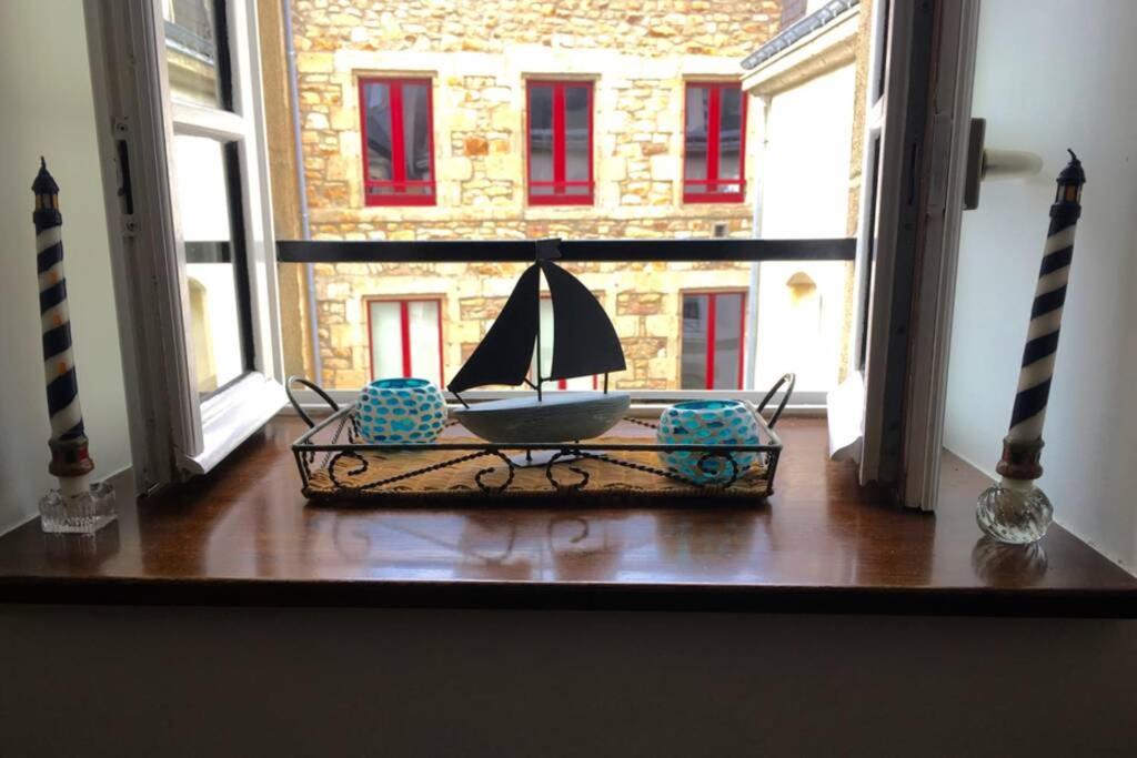 a room with a table with a sail boat on it at Appartement de charme rue du Château in Auray