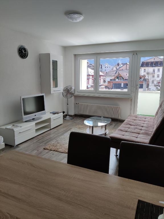 a living room with a couch and a tv at Apartment Tony in Interlaken