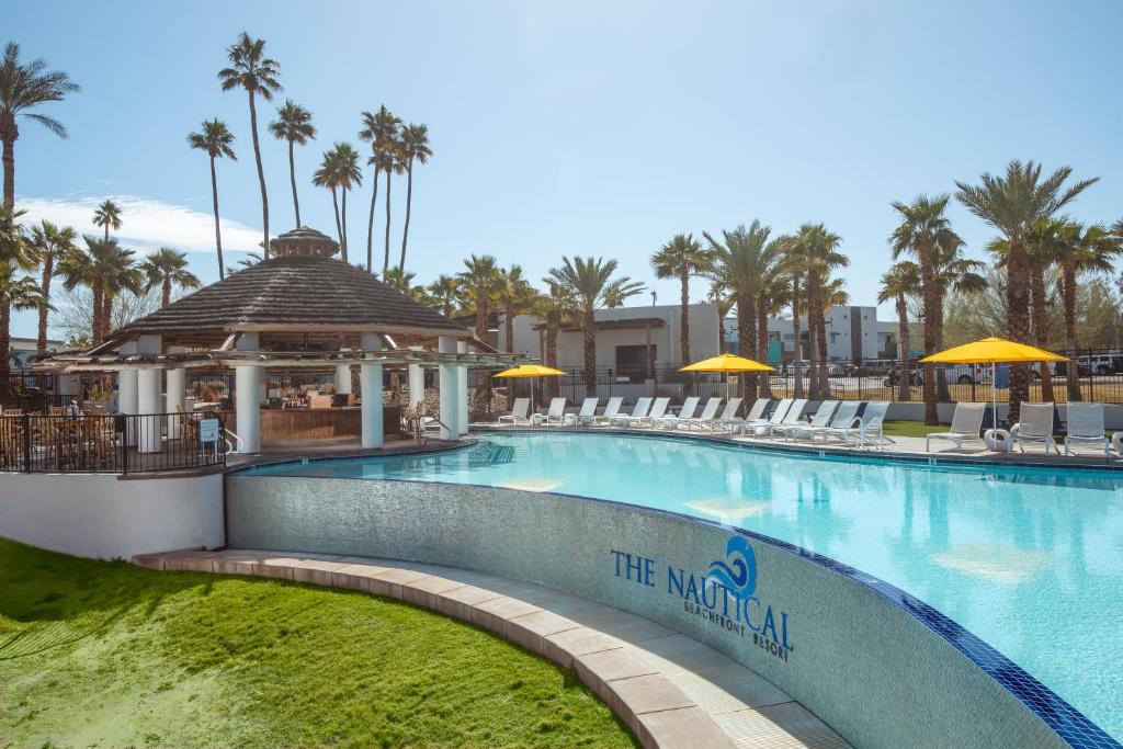 - une piscine dans un complexe avec des chaises et un kiosque dans l'établissement The Nautical Beachfront Resort, à Lake Havasu City