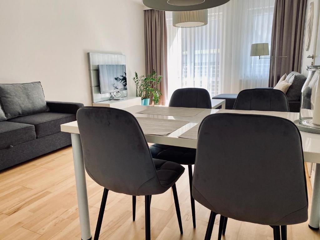 a living room with a dining room table and chairs at Apartamenty Maritimo in Kołobrzeg