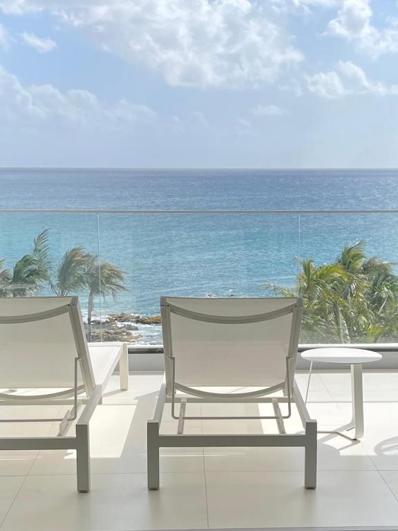 two chairs and a table on a balcony with the ocean at The Morgan Resort Spa & Village in Simpson Bay