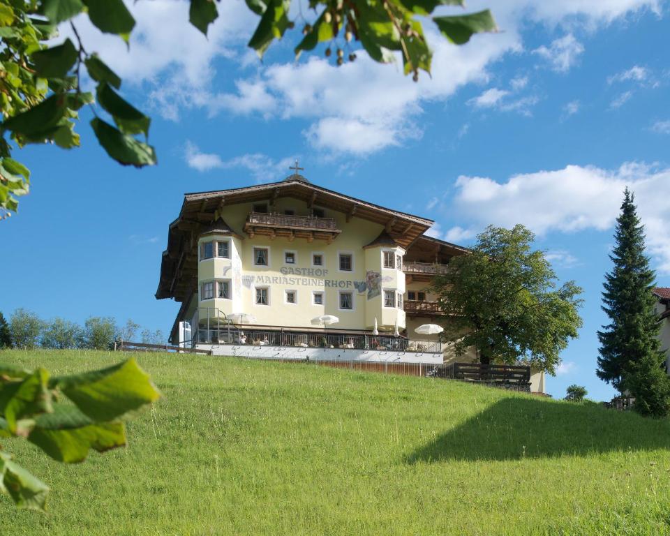 ein Haus auf einem Hügel mit einem grünen Feld in der Unterkunft Hotel Mariasteinerhof in Mariastein