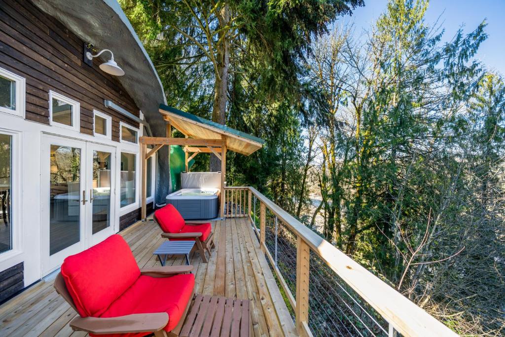 une terrasse avec deux chaises rouges et un grill dans l'établissement McKenzie View Cottage, à Deerhorn