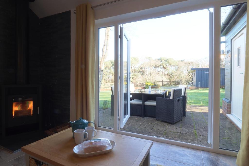 een woonkamer met een grote glazen schuifdeur bij The Tack Room - Perfect for Two in Redlynch