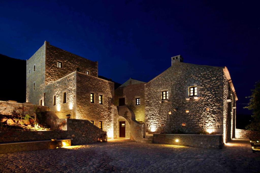 ein großes Steingebäude mit Nachtlicht in der Unterkunft Petritis Guesthouse in Neon Oitilon