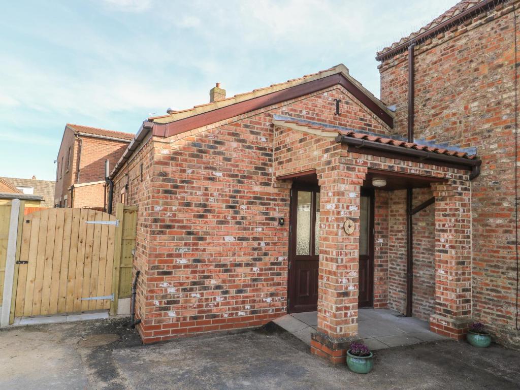 a brick building with a door and a fence at Shamrock in Selby