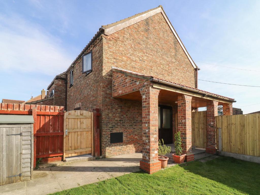 a brick house with a wooden fence at Rose in Selby