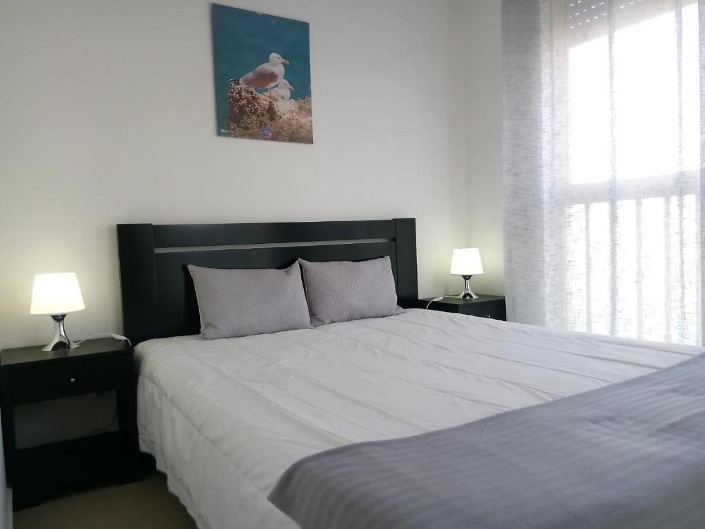 クアルテイラにあるDunas 3- Elegante, 150mt Praia, Wifiのベッドルーム1室(大型ベッド1台、ランプ2つ付)