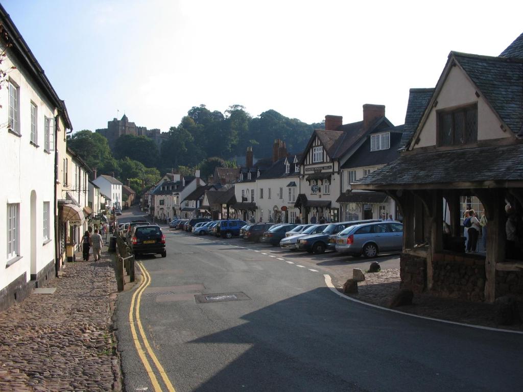 a street in a small town with cars parked at House in historic village - Sleeps 6 in Minehead