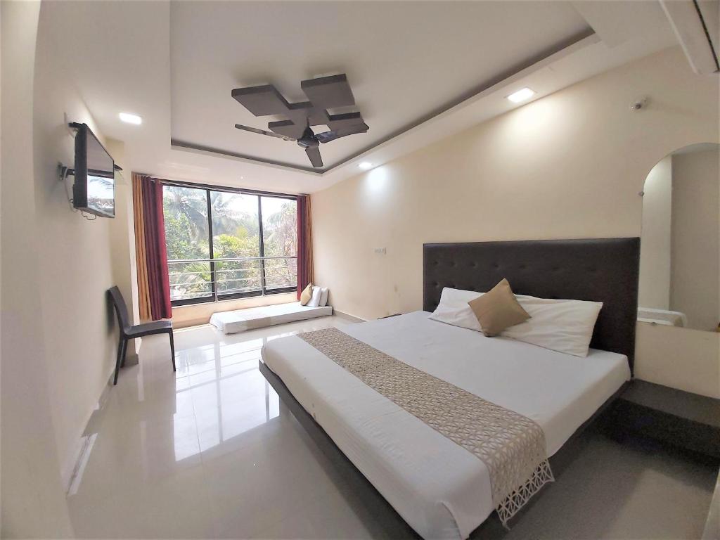 a bedroom with a large bed and a window at Swastic Hotel at Calangute GOA in Calangute