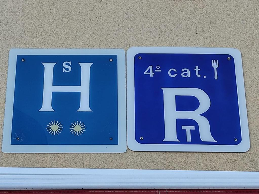 two blue signs on the side of a wall at hostal restaurante el abad in Abadía