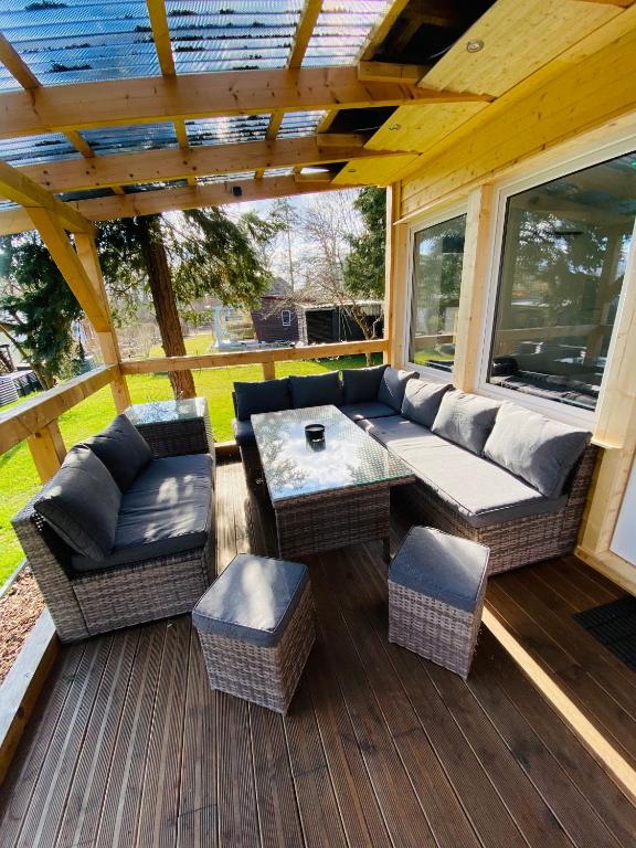 a patio with a couch and a table on a deck at Moderner Einraumbungalow auf eigenem Grundstück in Flecken Zechlin