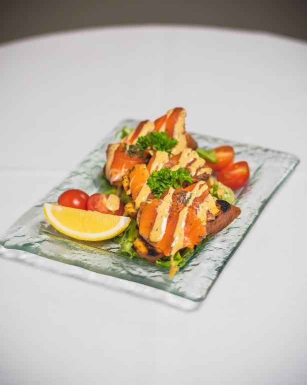 a plate of food with fish and vegetables and a lemon at Hótel Dyrhólaey in Vík