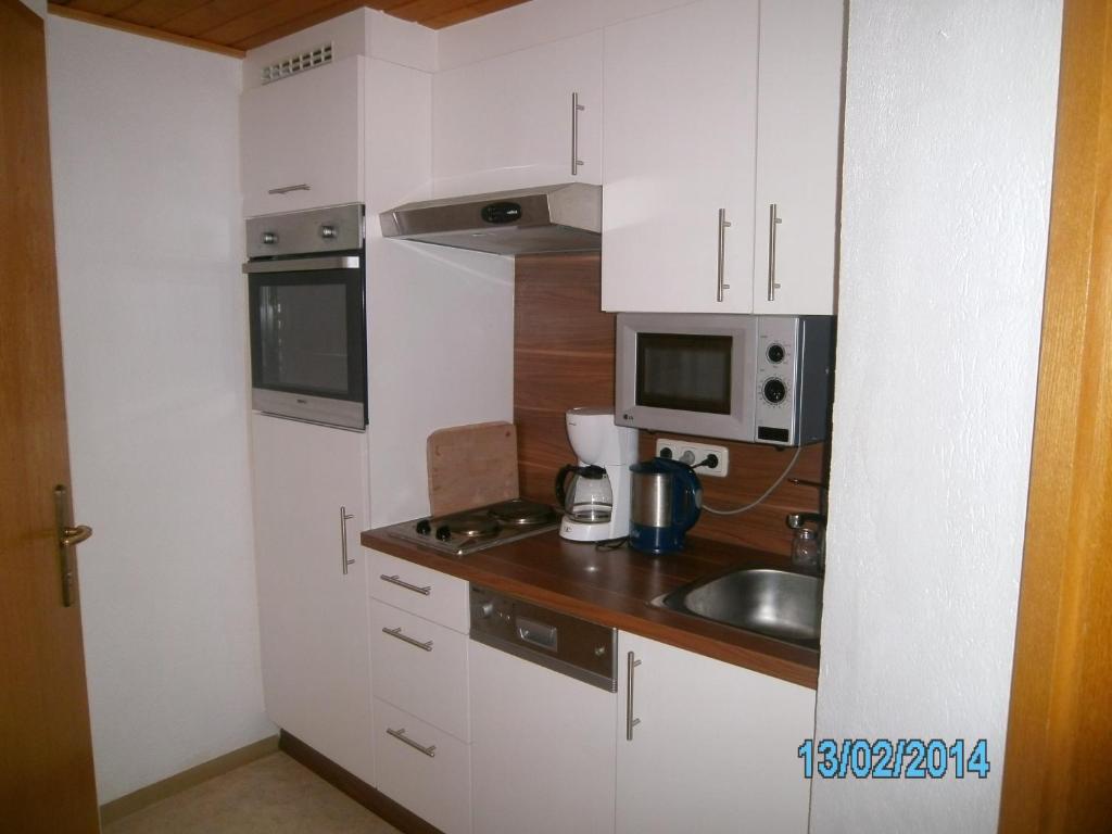 a small kitchen with a sink and a microwave at Gästehaus Hirschenhof in Sölden