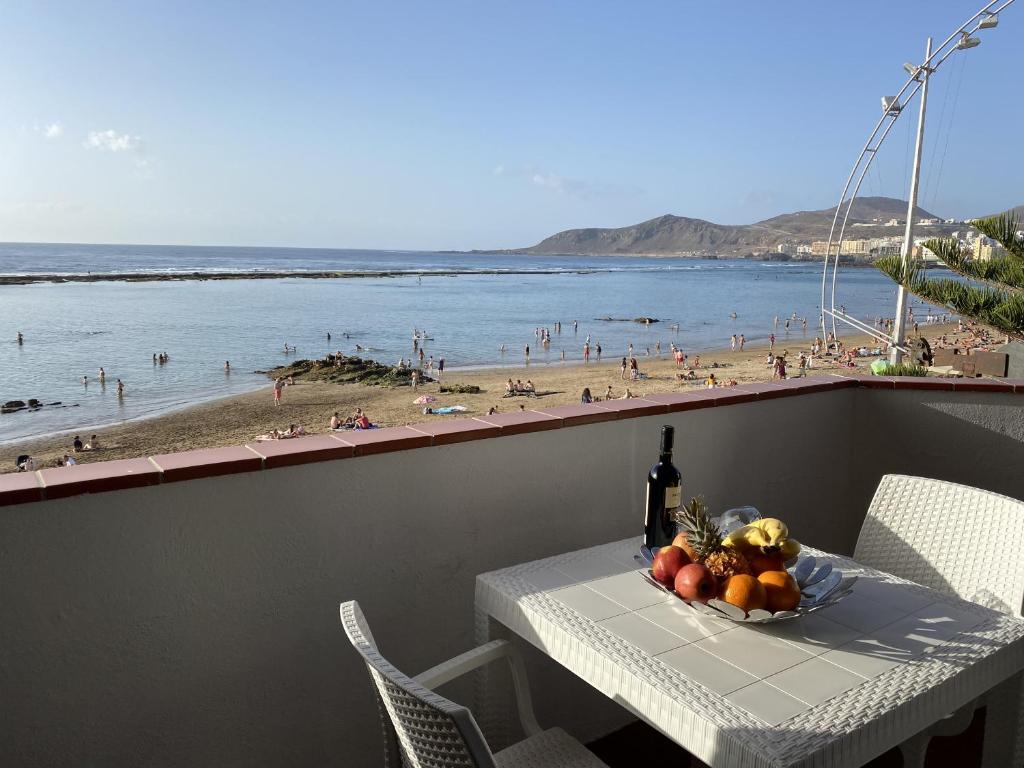 - une table avec un bol de fruits et une vue sur la plage dans l'établissement Vista Dorada al mar balcón-Wifi By CanariasGetaway, à Las Palmas de Gran Canaria