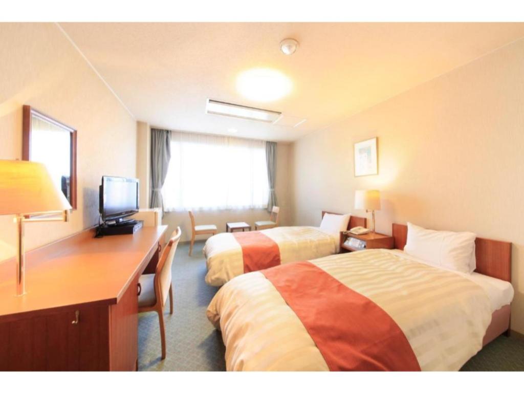 um quarto de hotel com duas camas e uma secretária em Fuji Green Hotel - Vacation STAY 18933v em Fuji