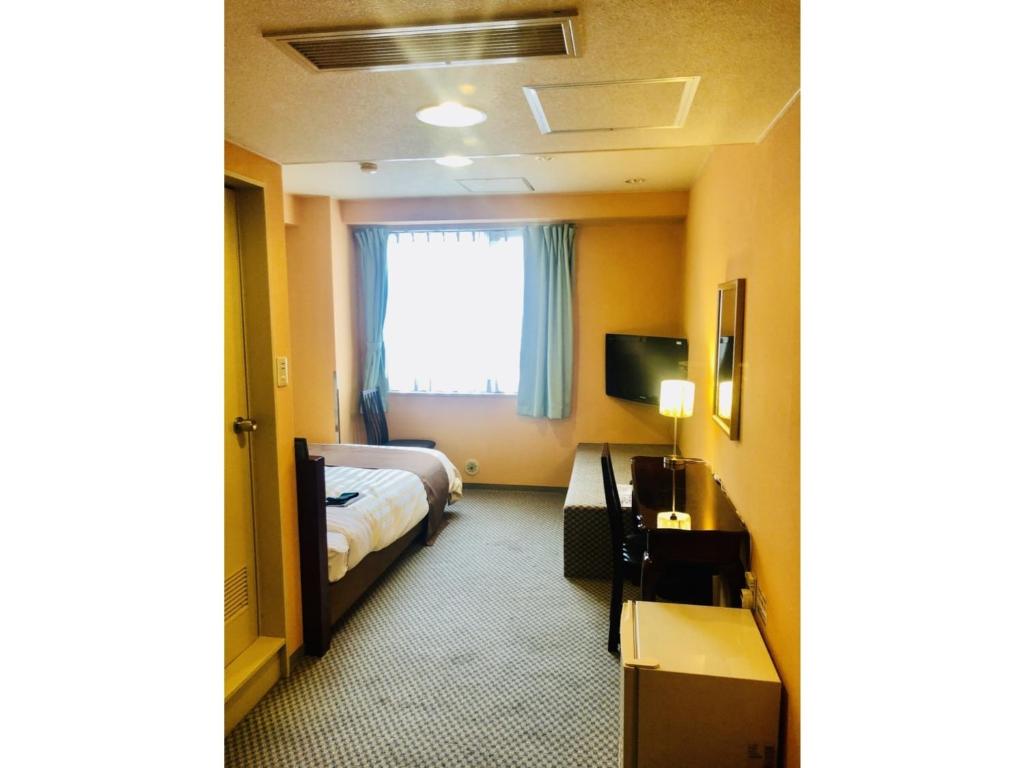 Fujinomiya Green Hotel - Vacation STAY 19020v في فوجينوميا: غرفه فندقيه بسرير ونافذه