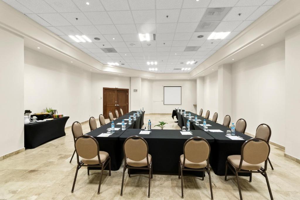 a conference room with a long table and chairs at Hotel Aeropuerto Los Cabos in San José del Cabo