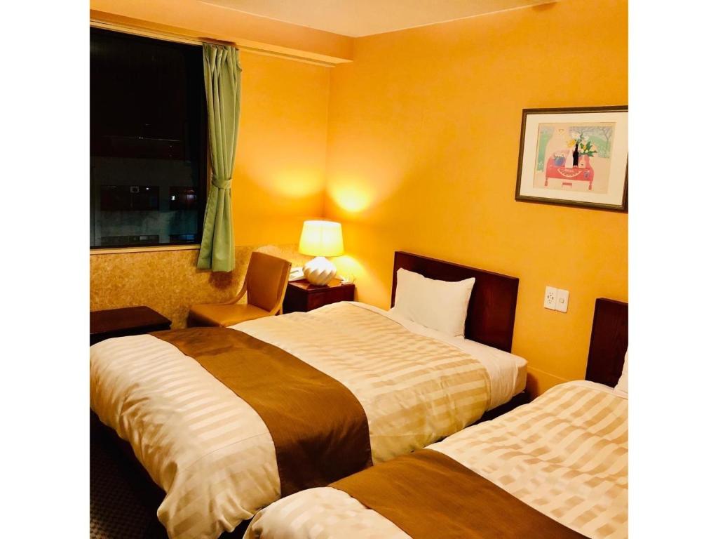 a hotel room with two beds and a window at Fujinomiya Green Hotel - Vacation STAY 19021v in Fujinomiya