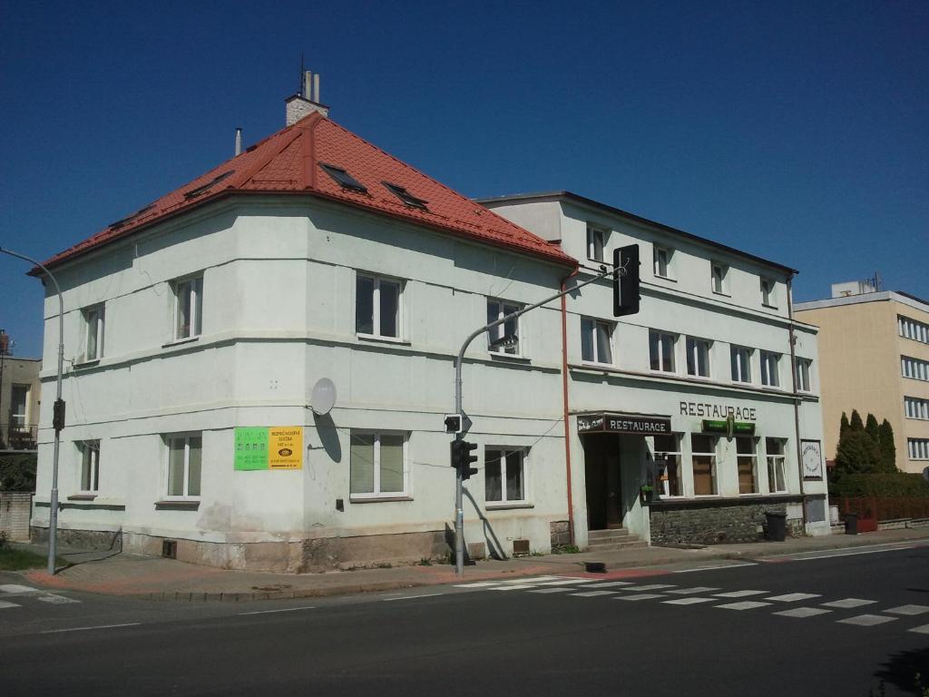 een wit gebouw met een rood dak op een straat bij Na 15 Kopách in Kolín